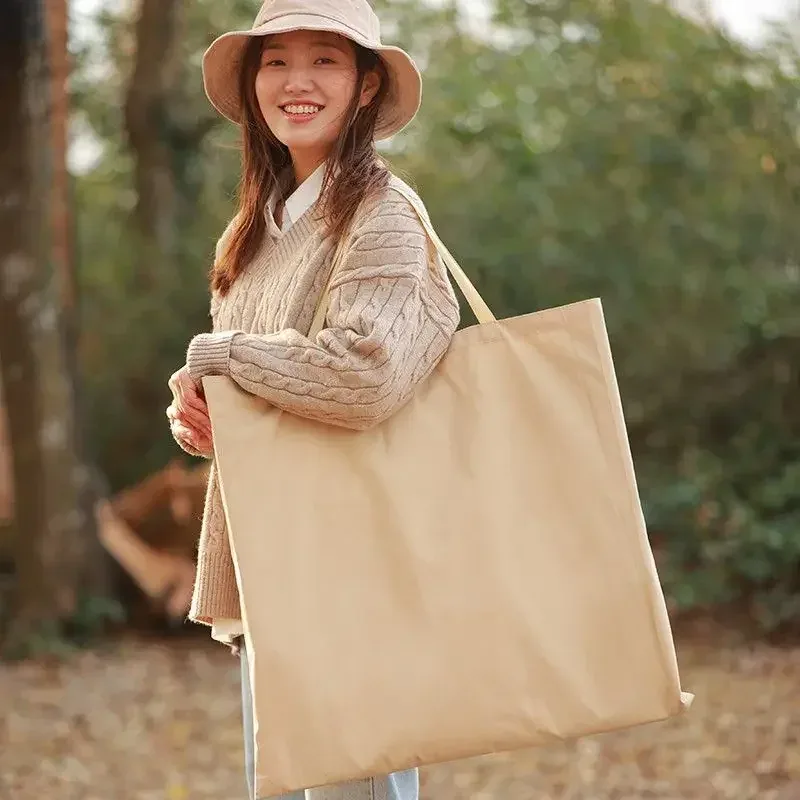 캠핑 의자 보관 가방을 어깨에 메고 있는 측면 모습